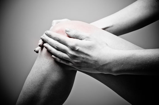woman holding injured knee